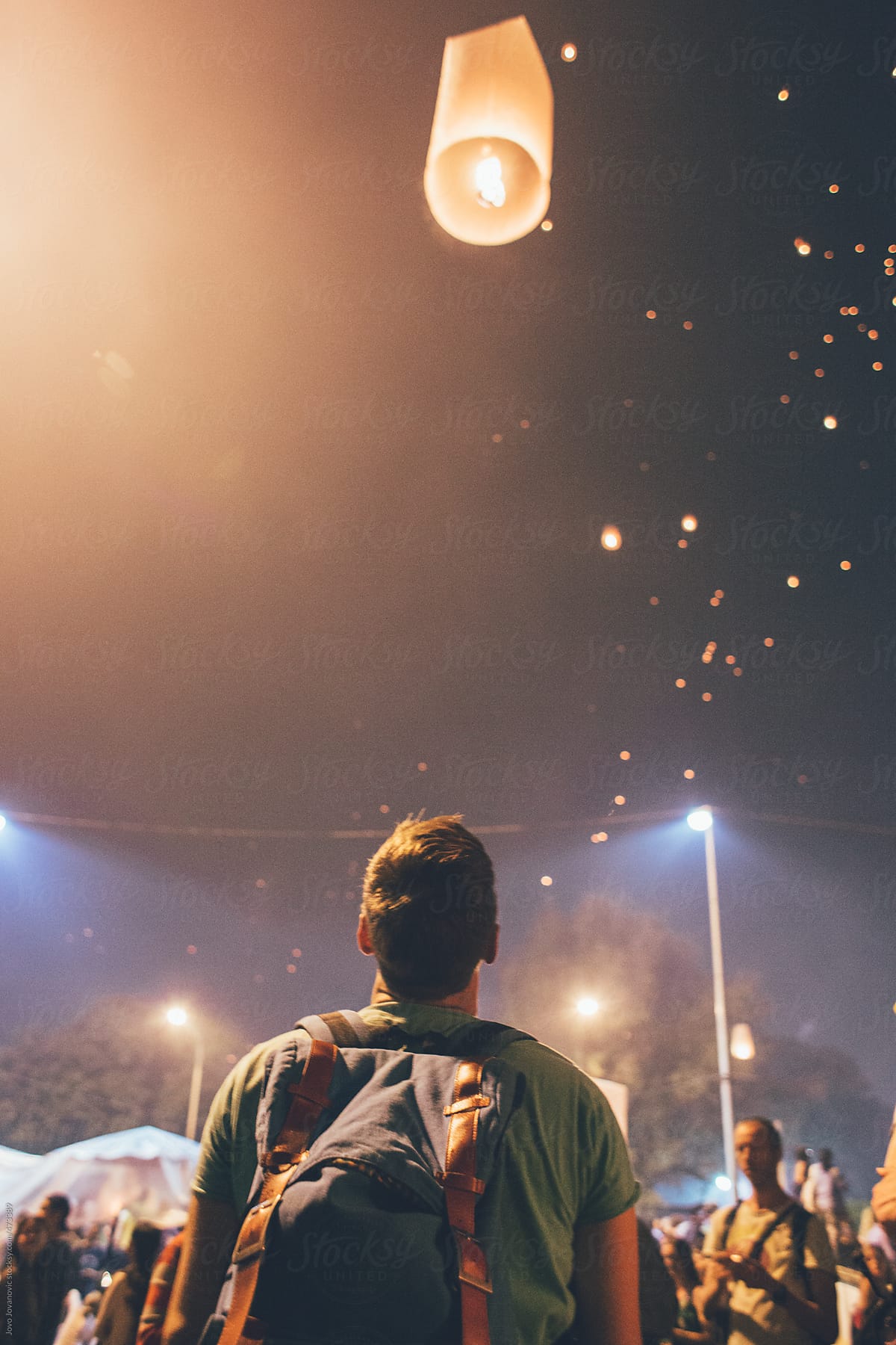 Festival time - Young man looking at fire lanterns and the sky during the night