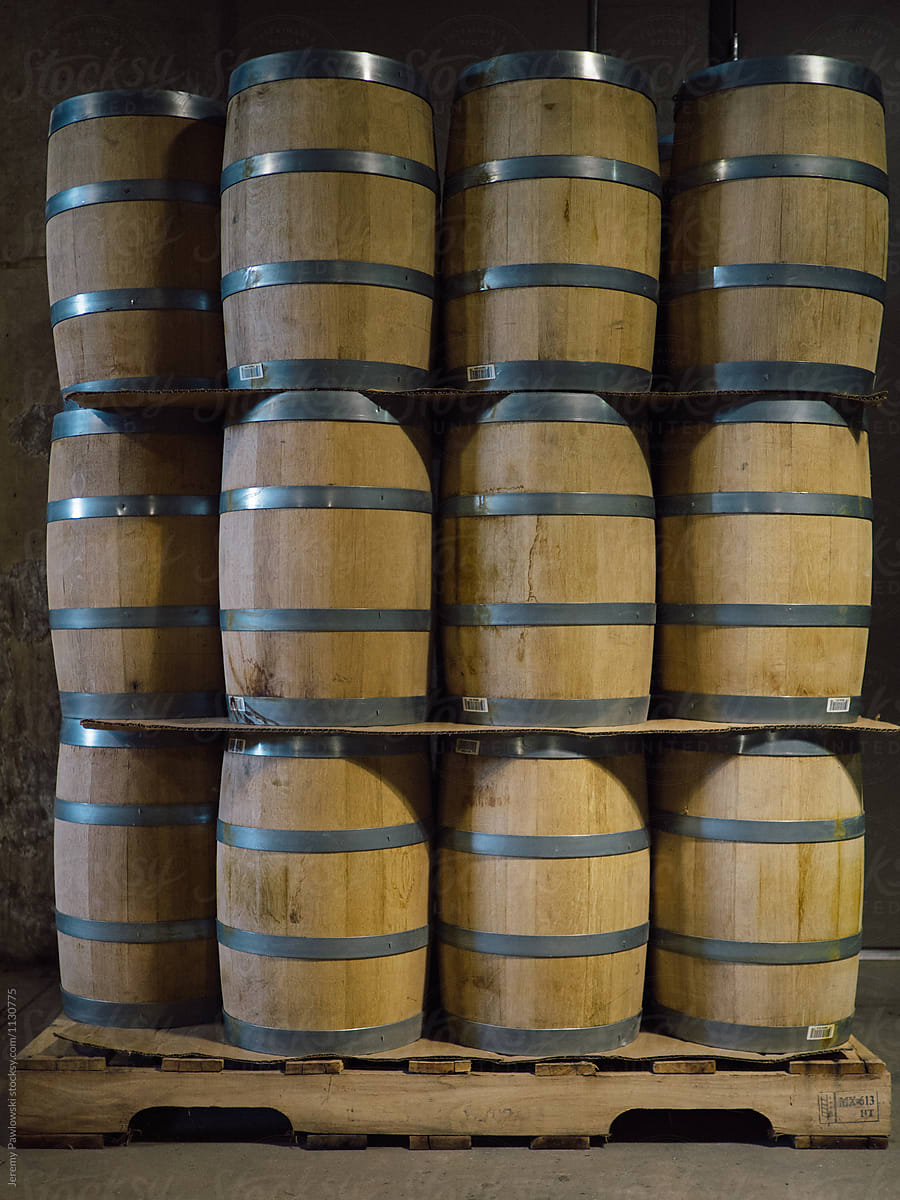Wooden barrels stacked in whiskey distillery factory