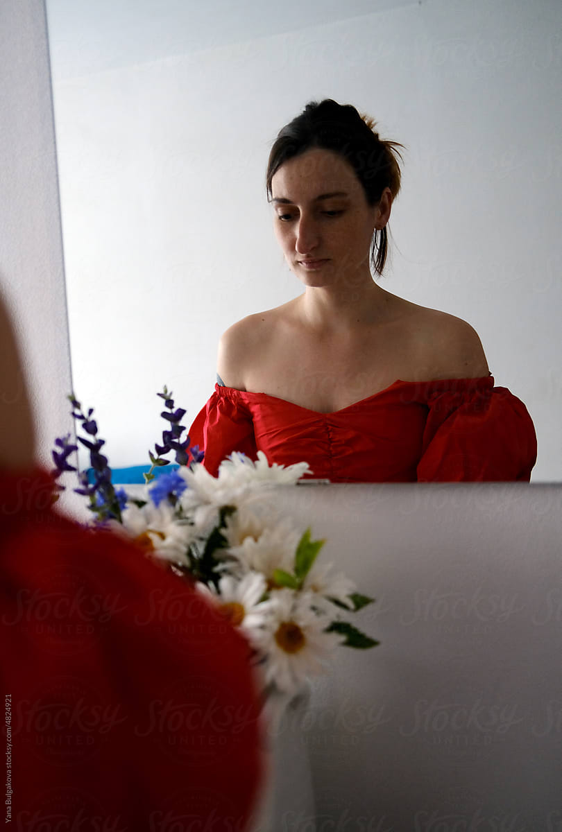 Girl with flowers looking at the mirror