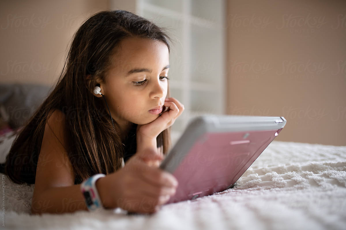 Girl with headphones looking at tablet