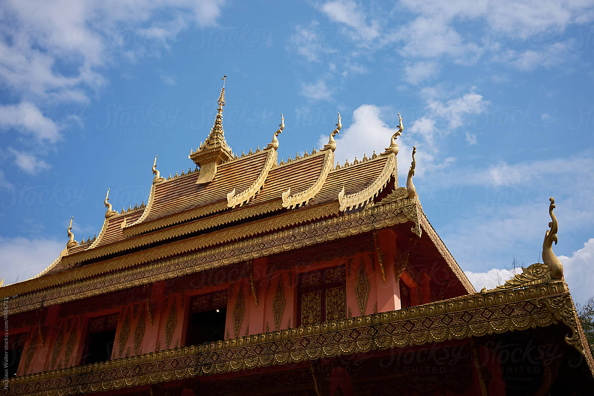 Golden Roof Of A Temple Under Blue Sky In Xishuangbanna, Yunnan, China
