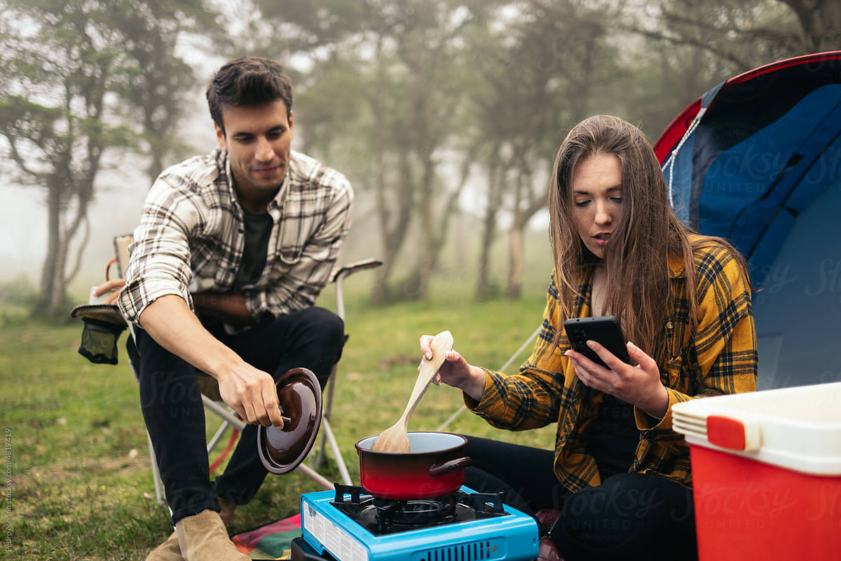 Couple camping and preparing food with camping gas