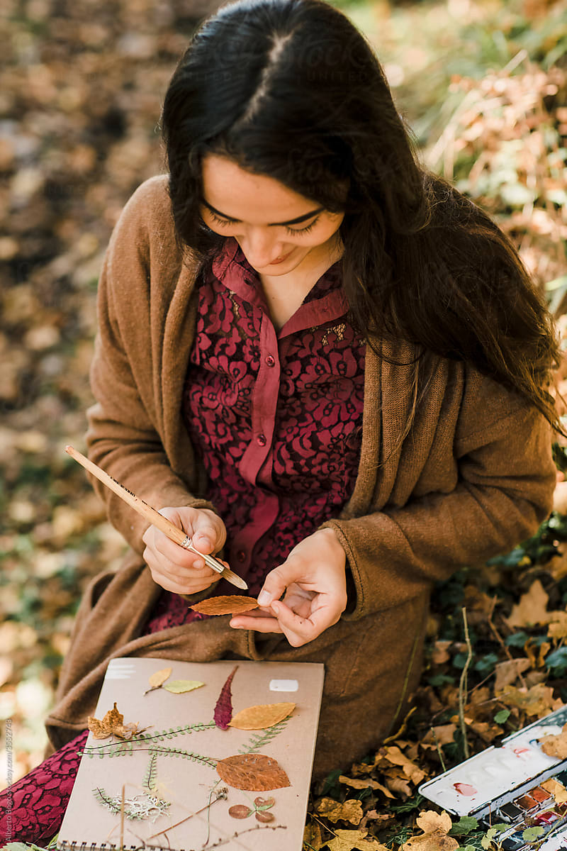 Portrait of a Smiling Young Woman Painting in the Wood