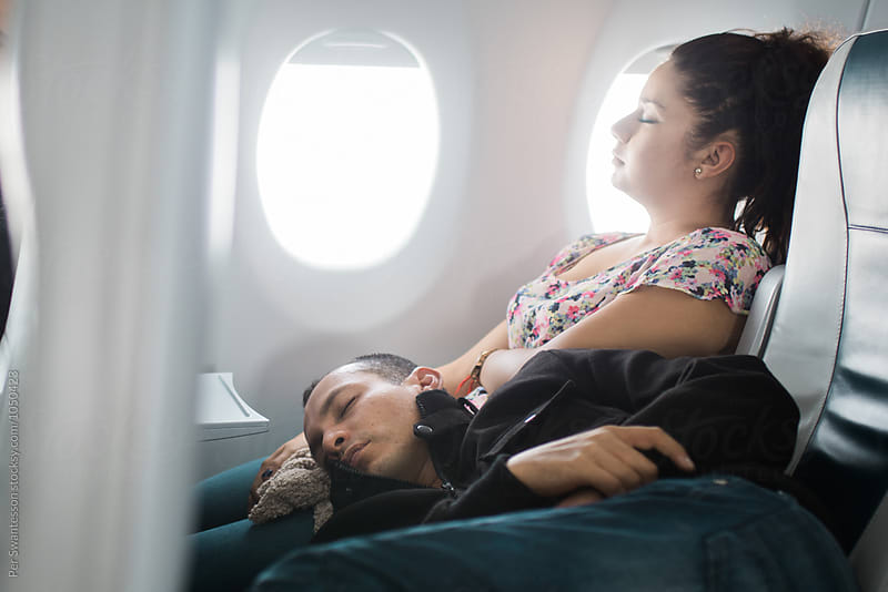 Young couple sleeping in an airplane