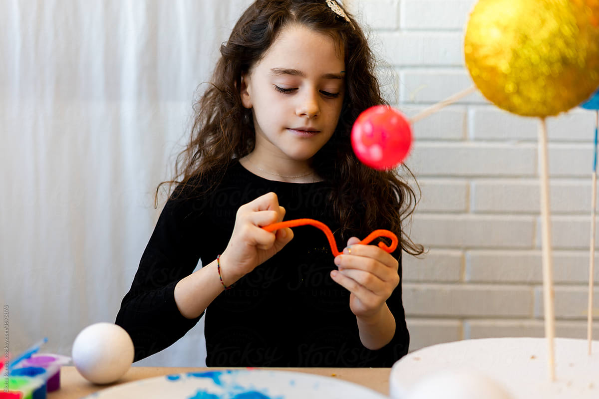 Little girl doing saturn's ring out of modeling clay