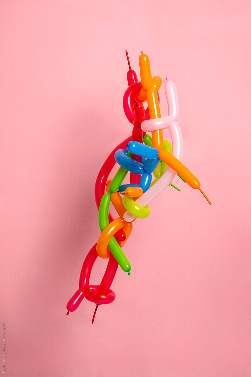 intertwined colored balloons on a pink background