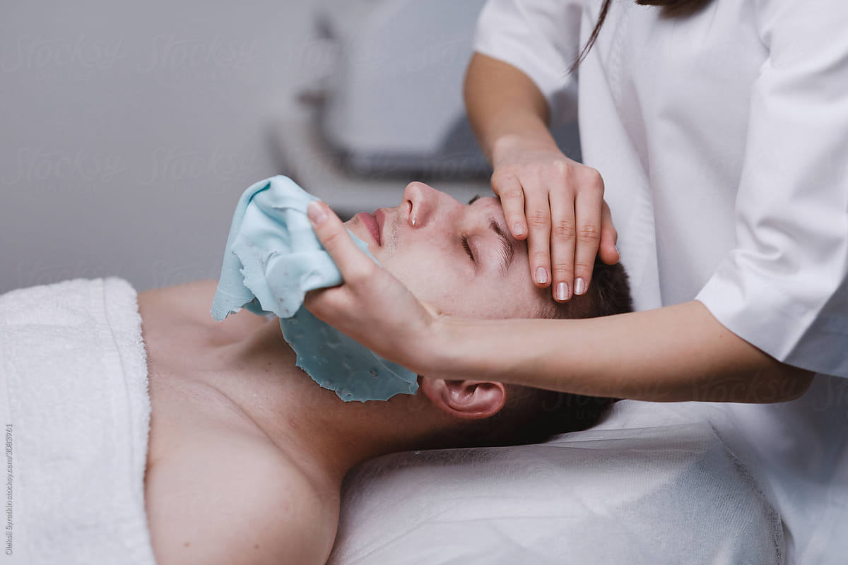 Cosmetologist taking off mask from face.