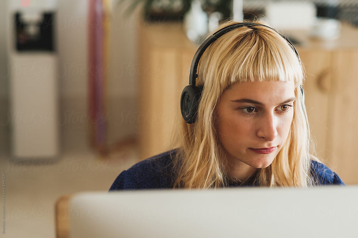 Close Up Of Blond Woman With Headphones Working At The Office