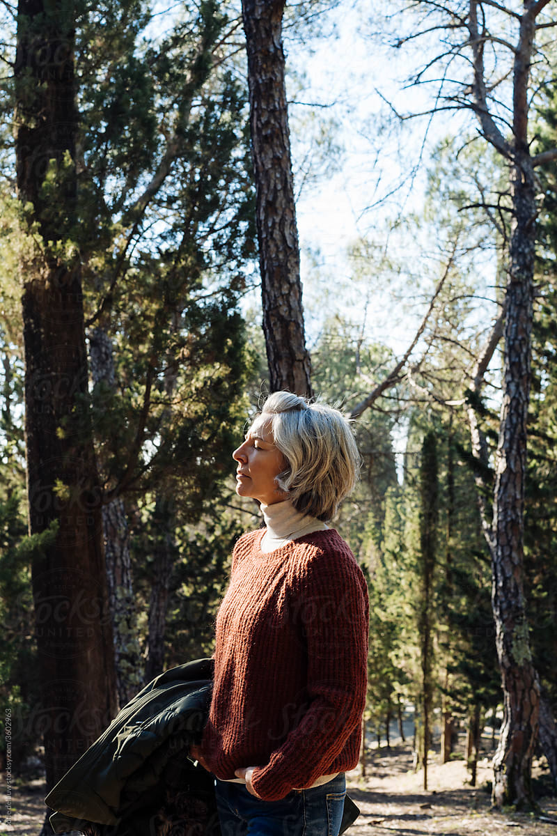 Mature woman breathing fresh forest air