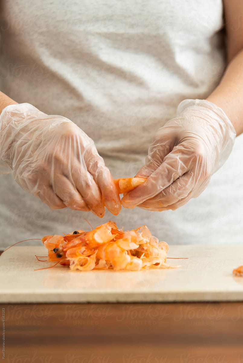 Preparing shrimp tacos: woman cleaning s shrimp in kitchen