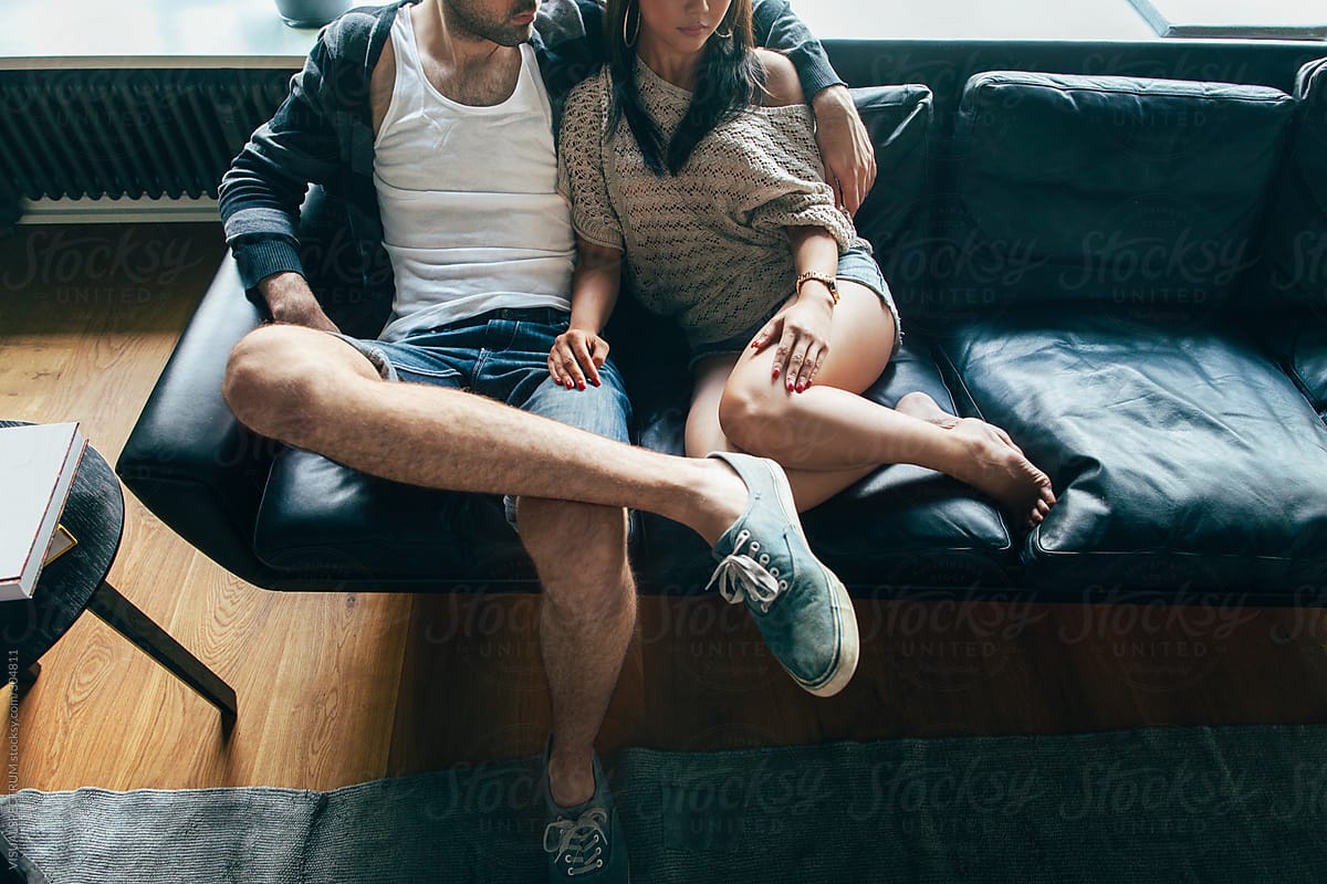 Trendy Couple Sitting Side by Side on Couch
