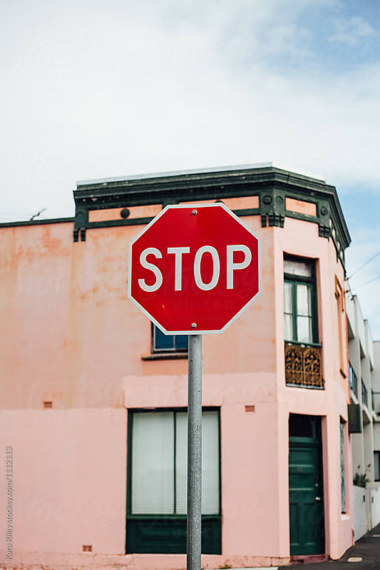 Stop sign in front of pink building