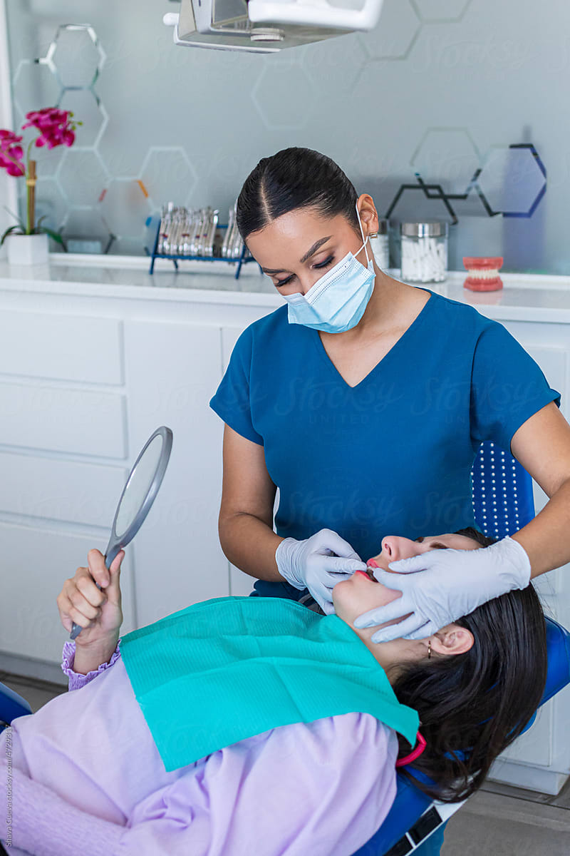 Dentist opening the mouth of a female patient