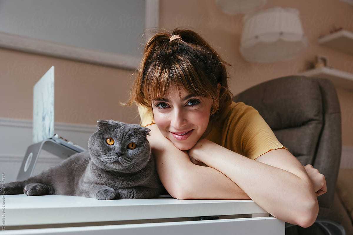 Young woman and cat looking at camera
