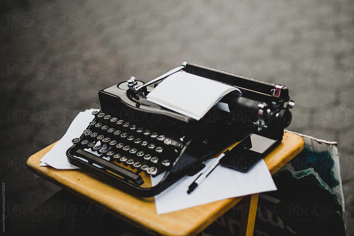 Black typewriter with empty pages outside