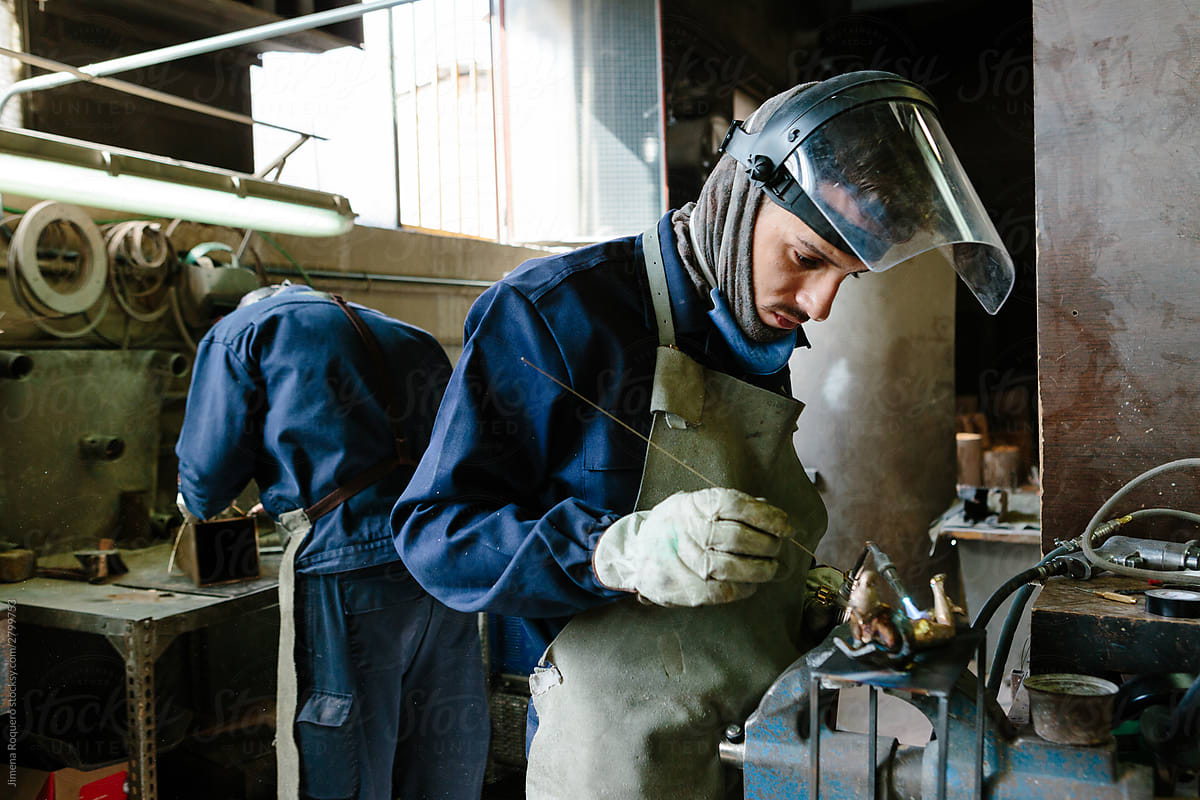 Man using a blowtorch in a foundry