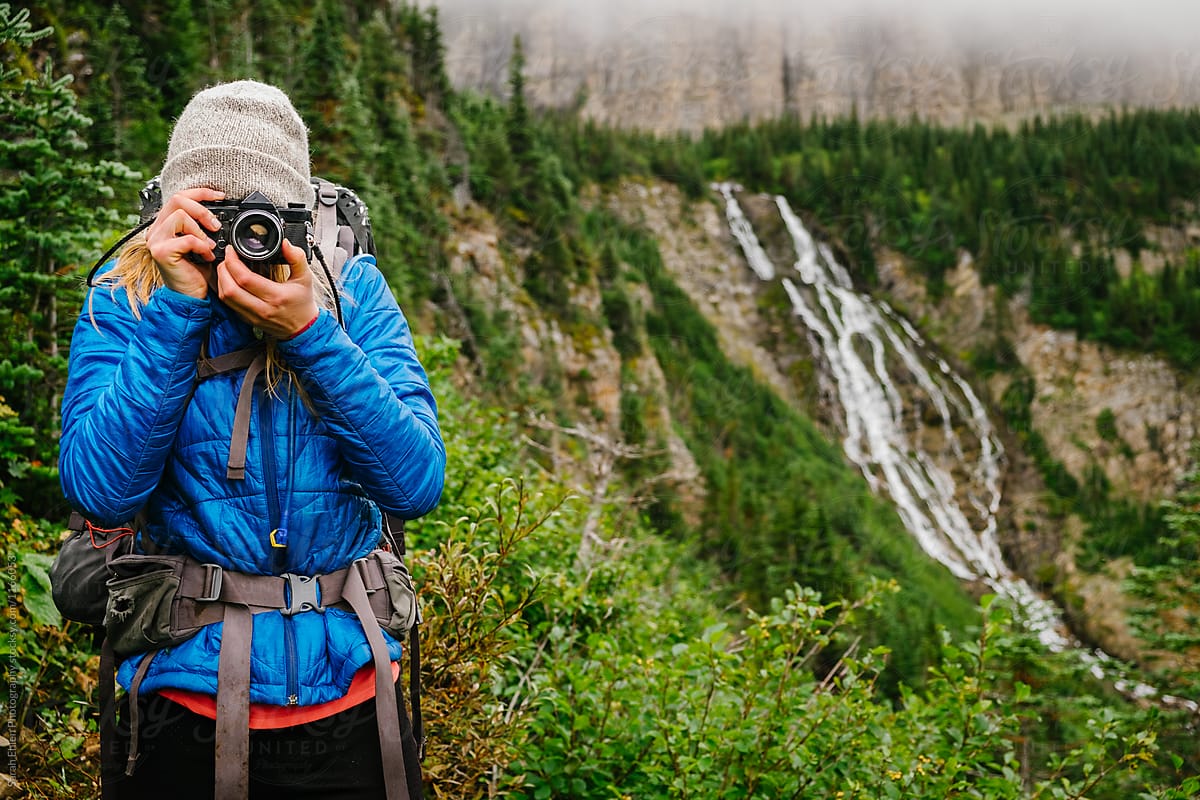 A young woman taking a photo in nature