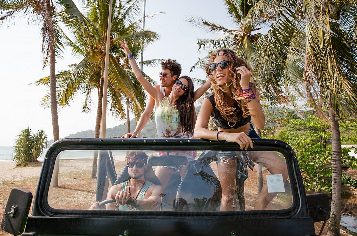 Group of friends exploring beach in Jeep