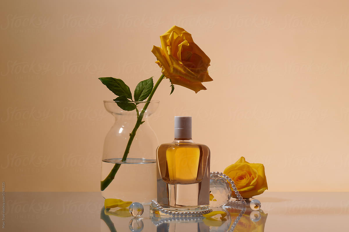 woman perfume in beautiful bottle and vase with yellow rose flowers