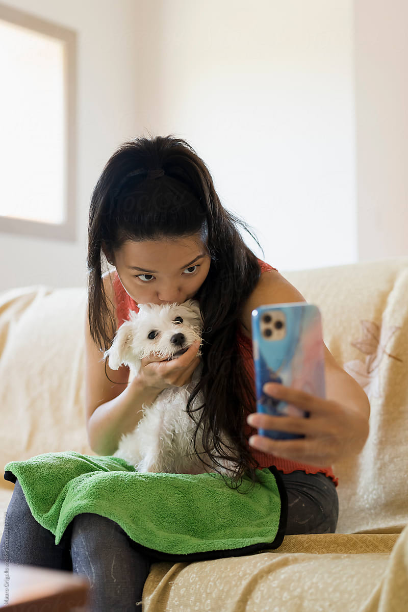 Asian woman taking a selfie with her dog