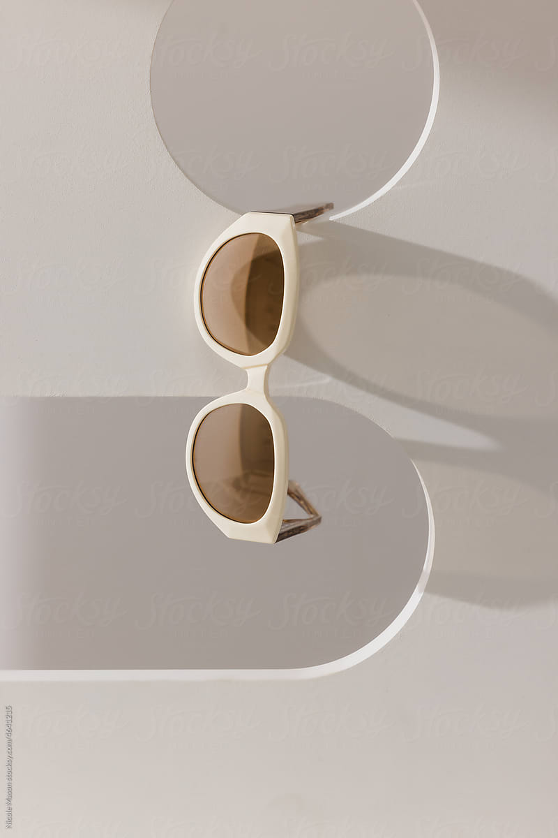 pair of sunglasses hanging on white shape with circle and arch