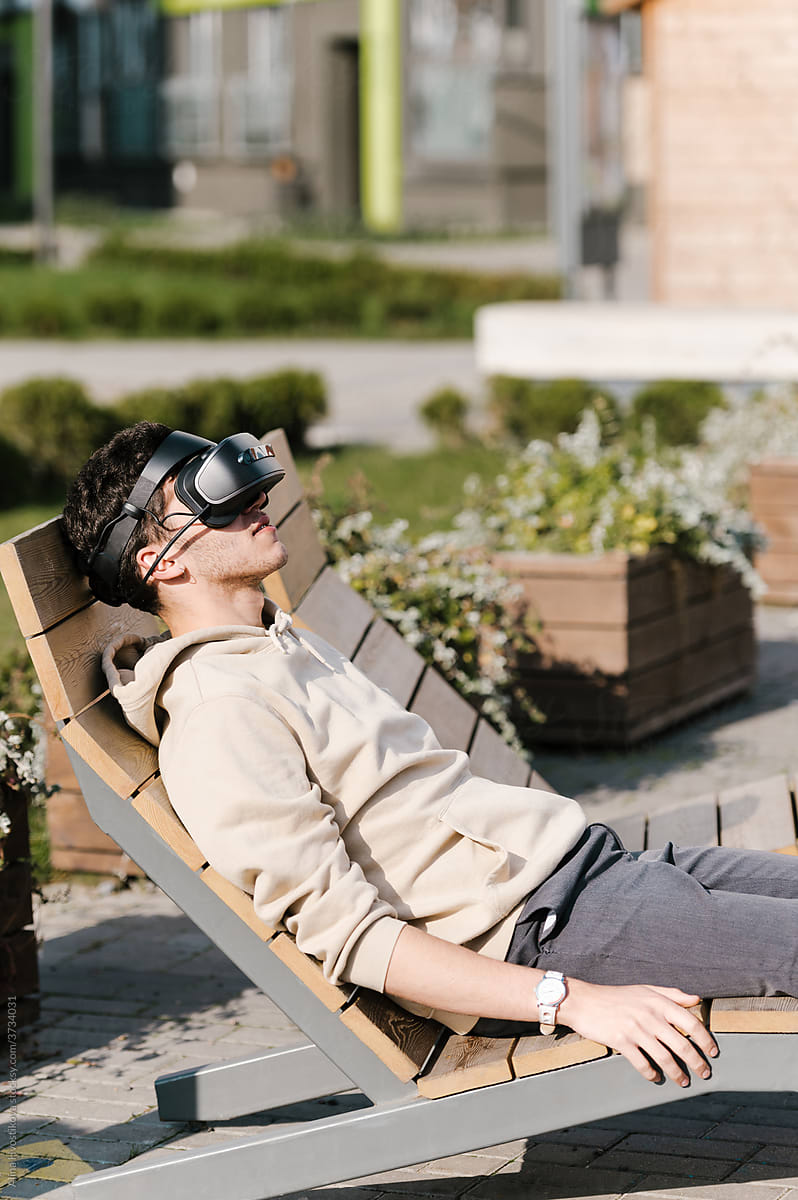 Glad man in VR glasses resting on lounger