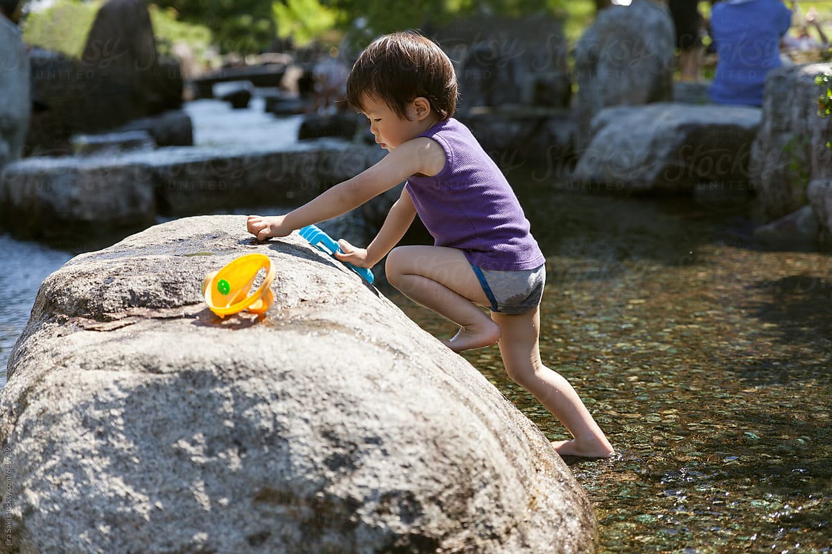 toddler playing water on the pond