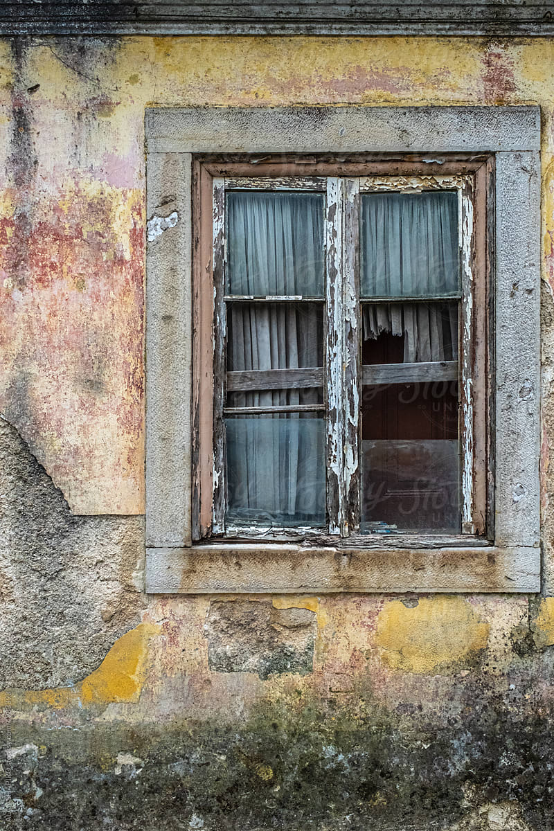 colorful old boarded-up window against a distressed wall