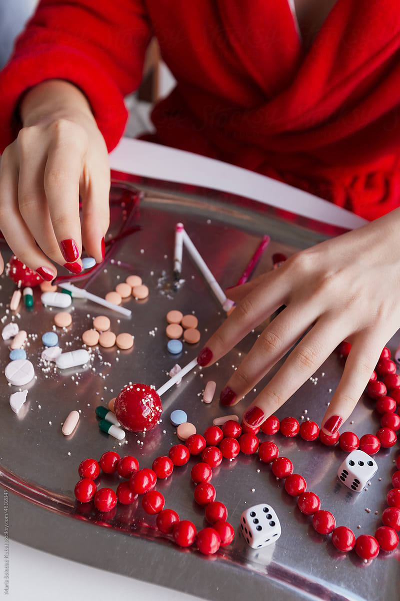 Hands of anonymous woman next to metal tray full of addictive elements
