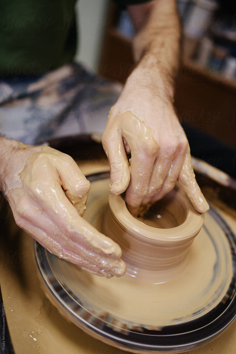 Hands create a clay bowl in a pottery workshop
