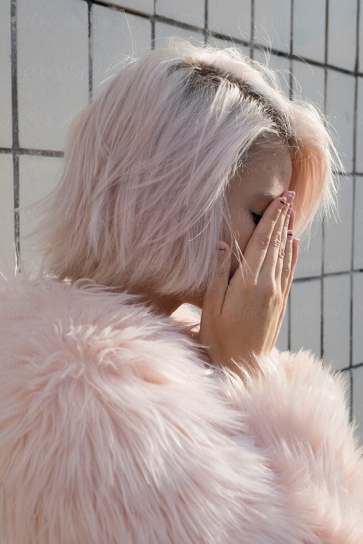 Close-up of sad blonde girl covering face with hands