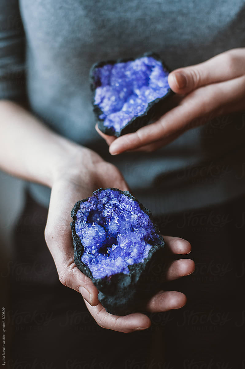Woman holding purple gemstones on her hands
