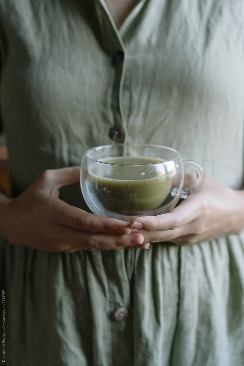 Pregnant woman holding cup of matcha tea