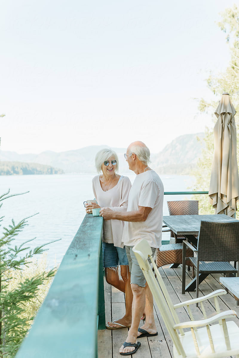 Happy elderly couple drinking coffee on deck
