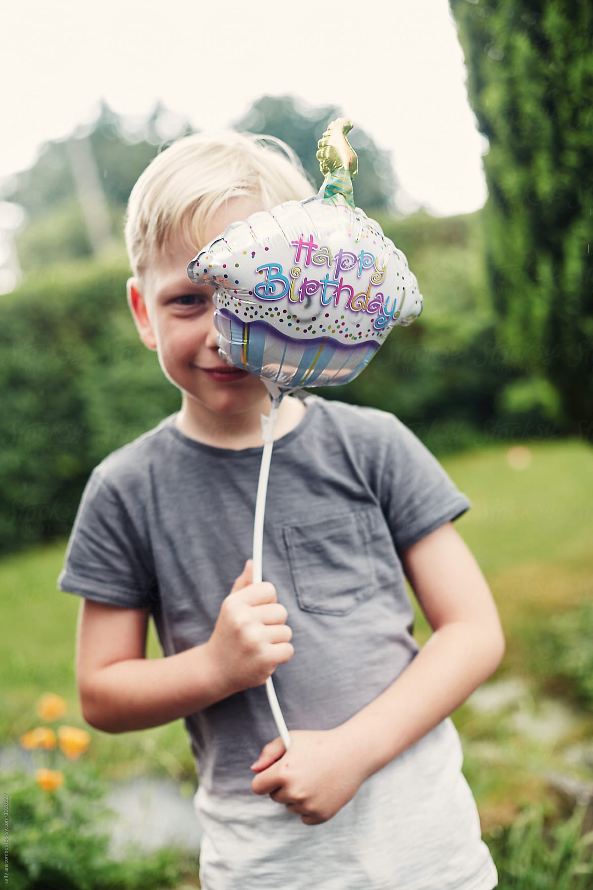 Child holding a happy birthday balloon