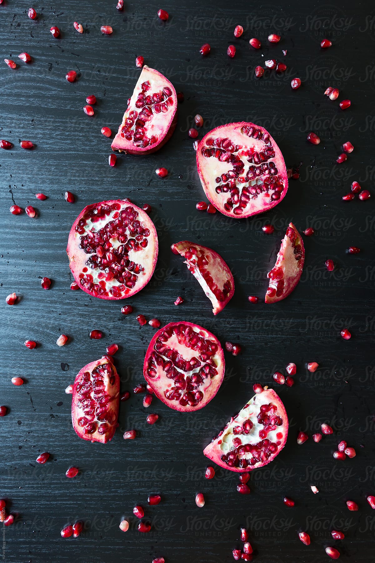 Graphic image of slices pomegranate and seeds on dark background