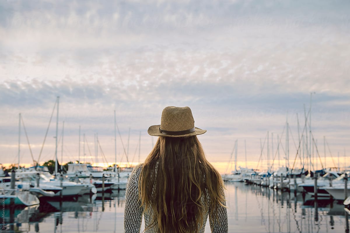 Woman watching sunrise over marina