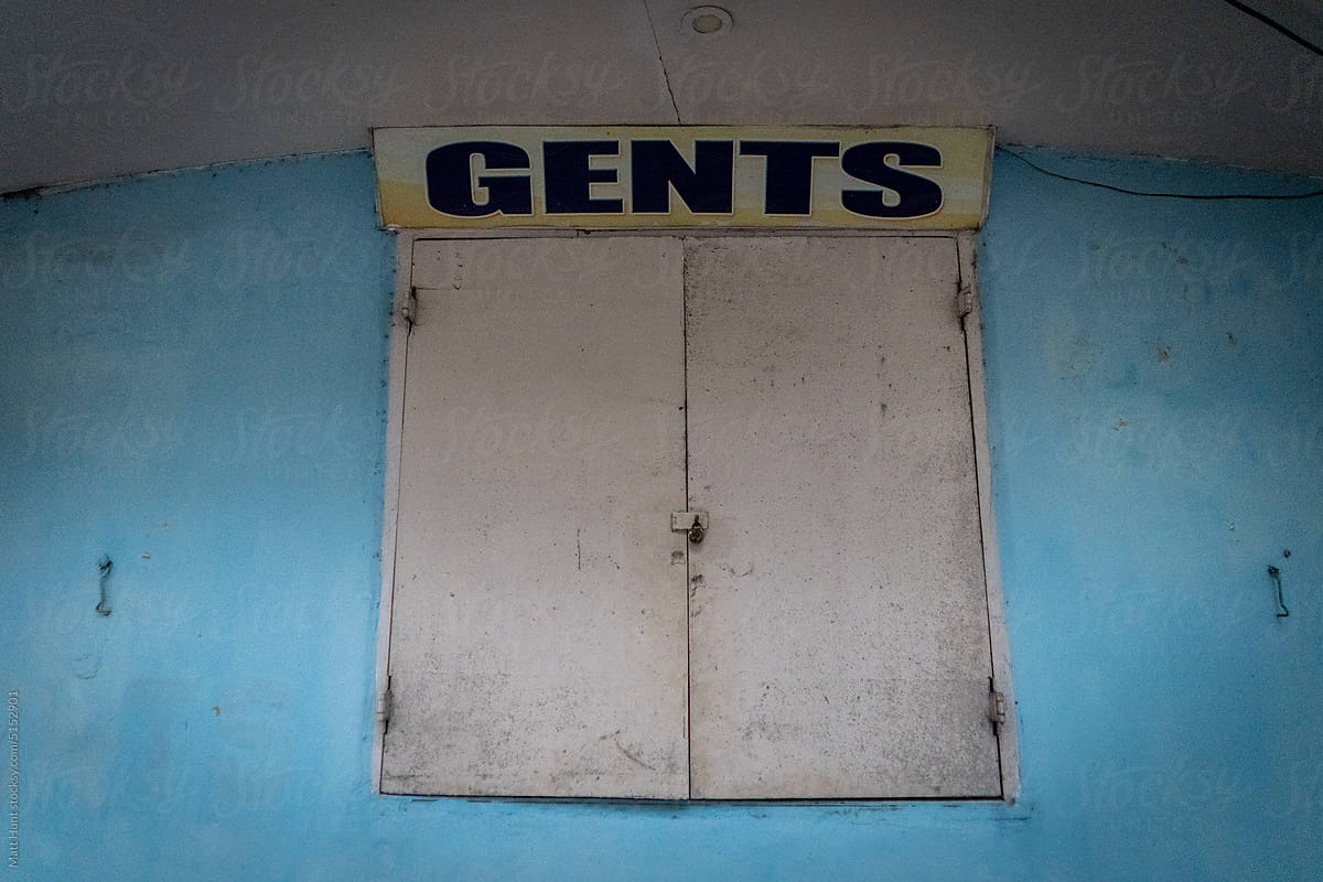 A window for gents to buy sundries at a small market store in India