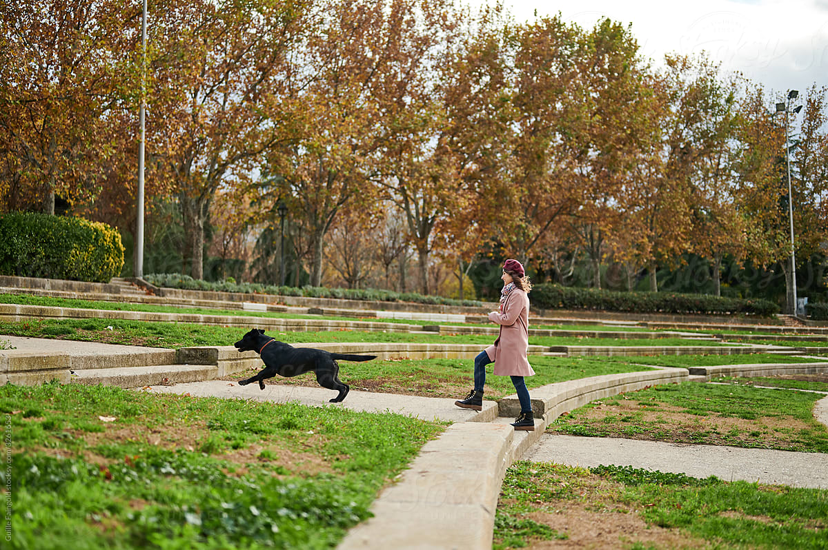 Woman walking with dog in autumn park