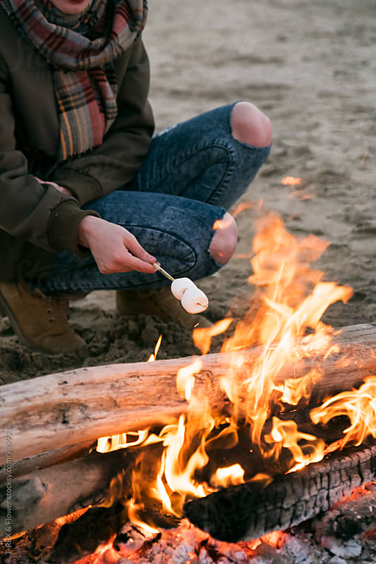 Girl roasting marshmallow at bonfire