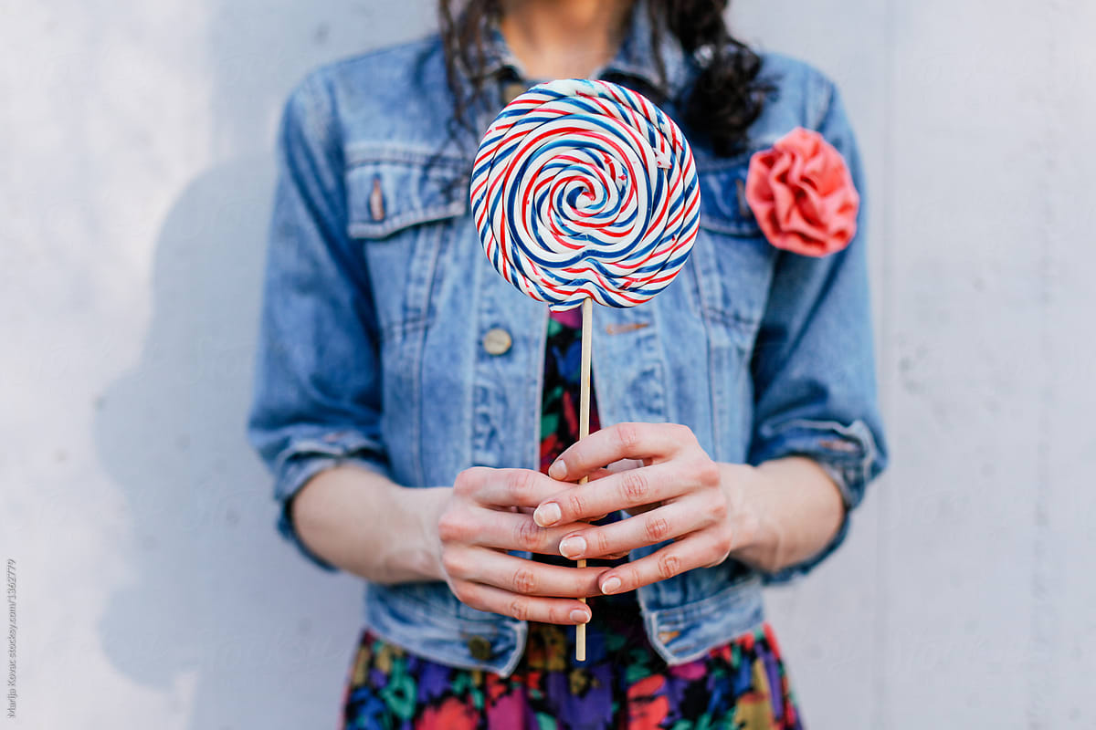 Anonymous female person holding a lollipop