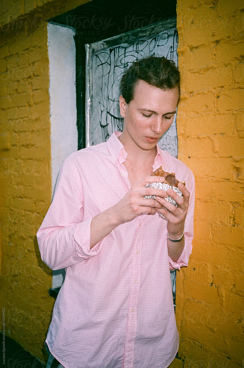 Man in a pink shirt looking to a delicious burger