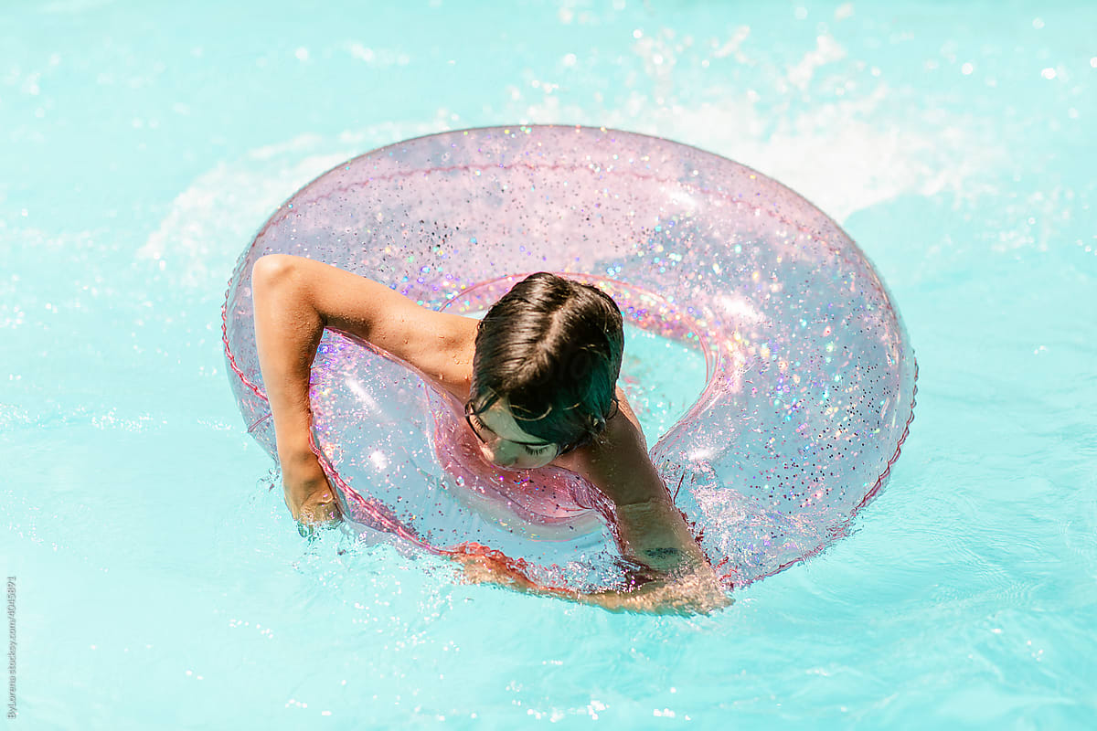Teenager with ring float in pool