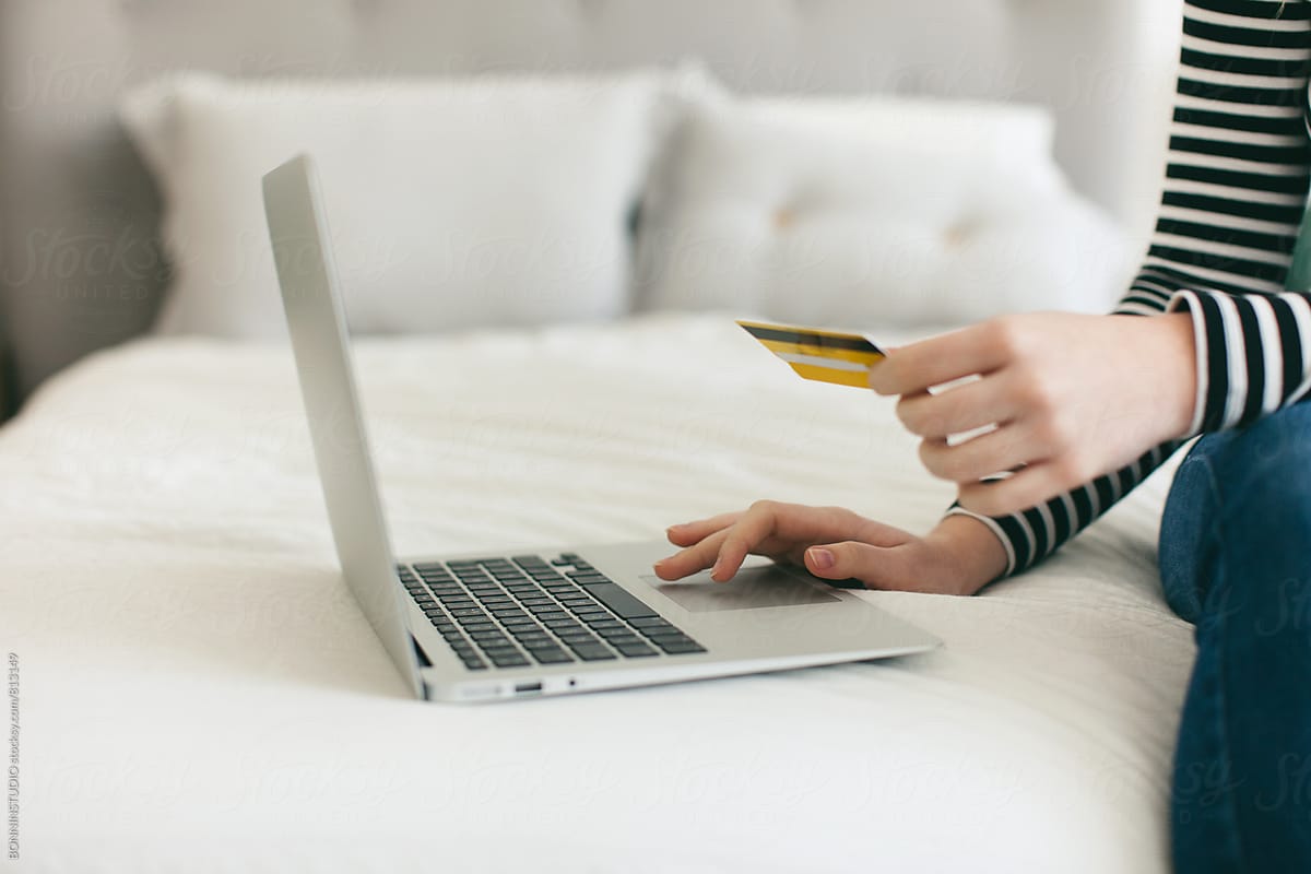 Closeup of a woman shopping online with her credit card from home.