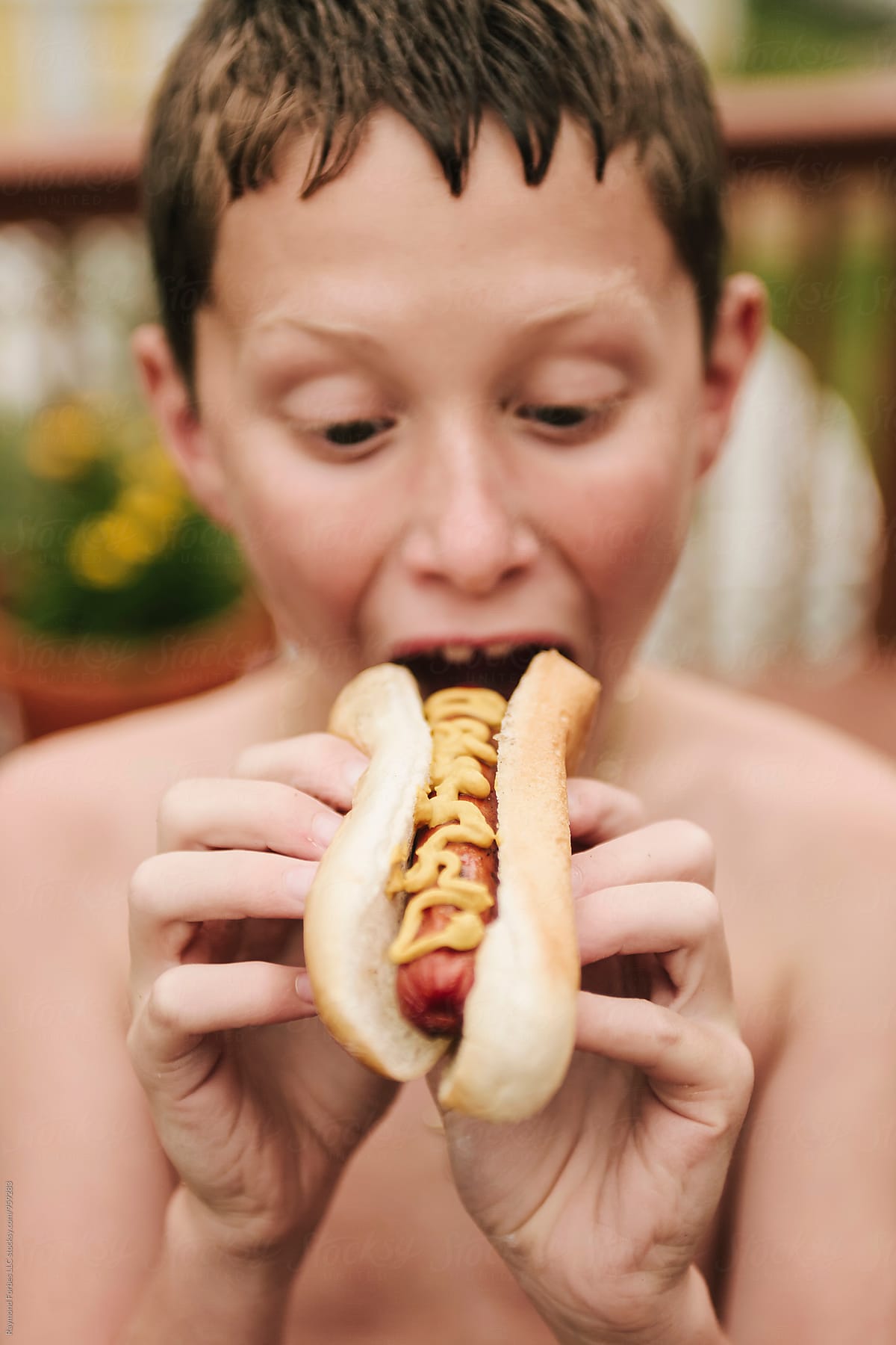 Child Eating Hot Dog at Summer Barbecue