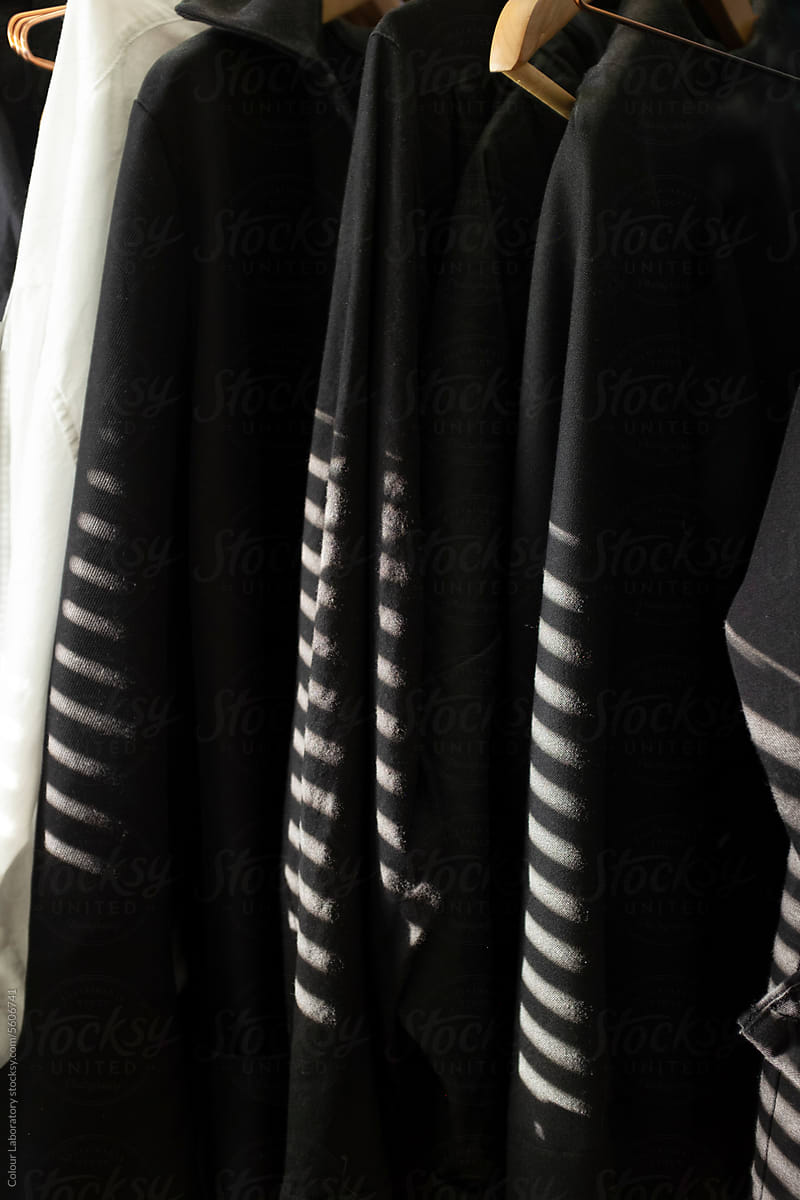 Closet clothes hanging on hangers on a clothes rack with beam of light