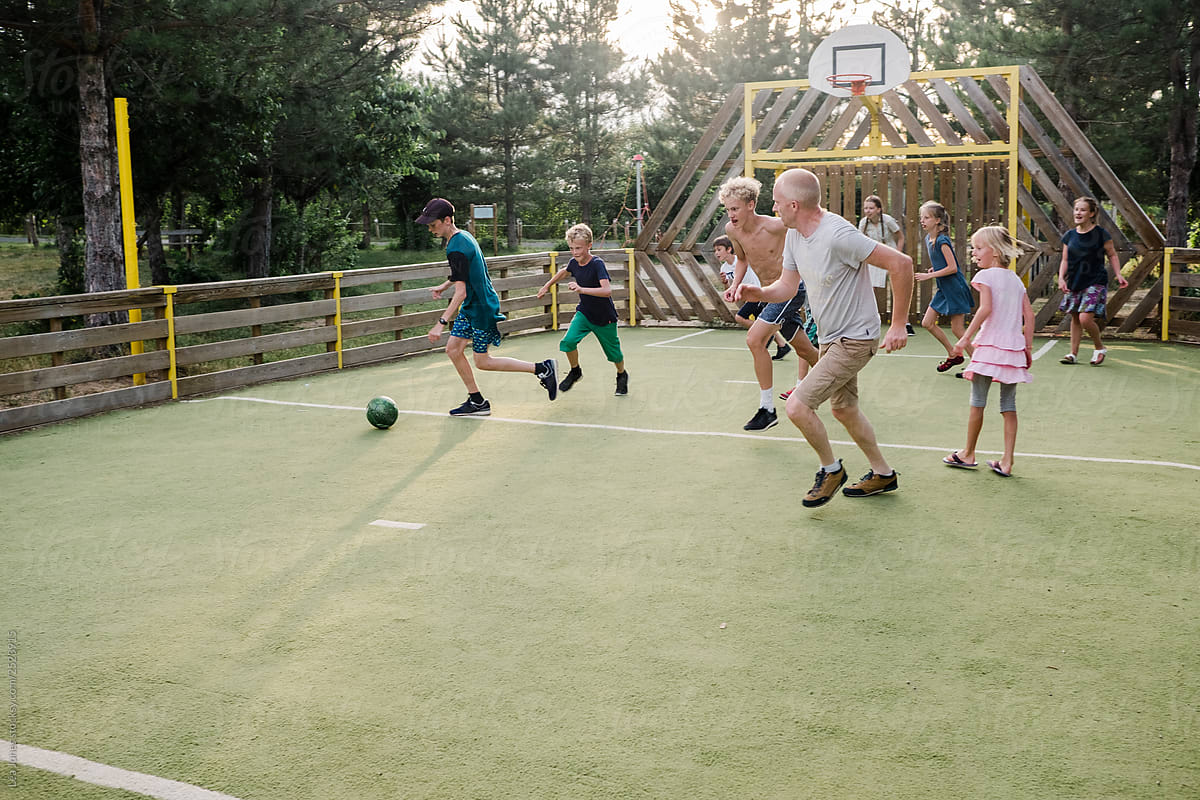 group of kids and two dad playing soccer