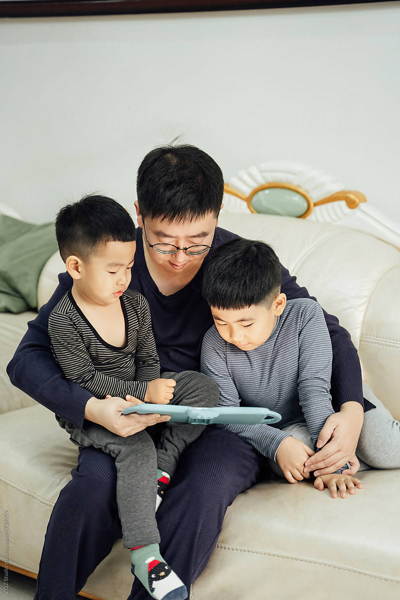 Asian father and toddler sons at home