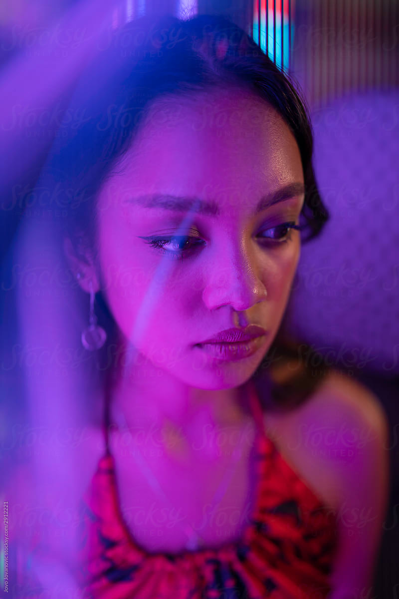 Young Asian Woman Looking Lonely Under Purple Light Del Colaborador De Stocksy Jovo Jovanovic