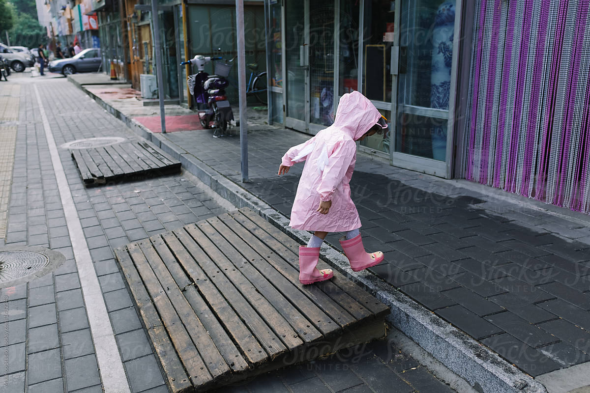 Little girl wearing raincoat on street
